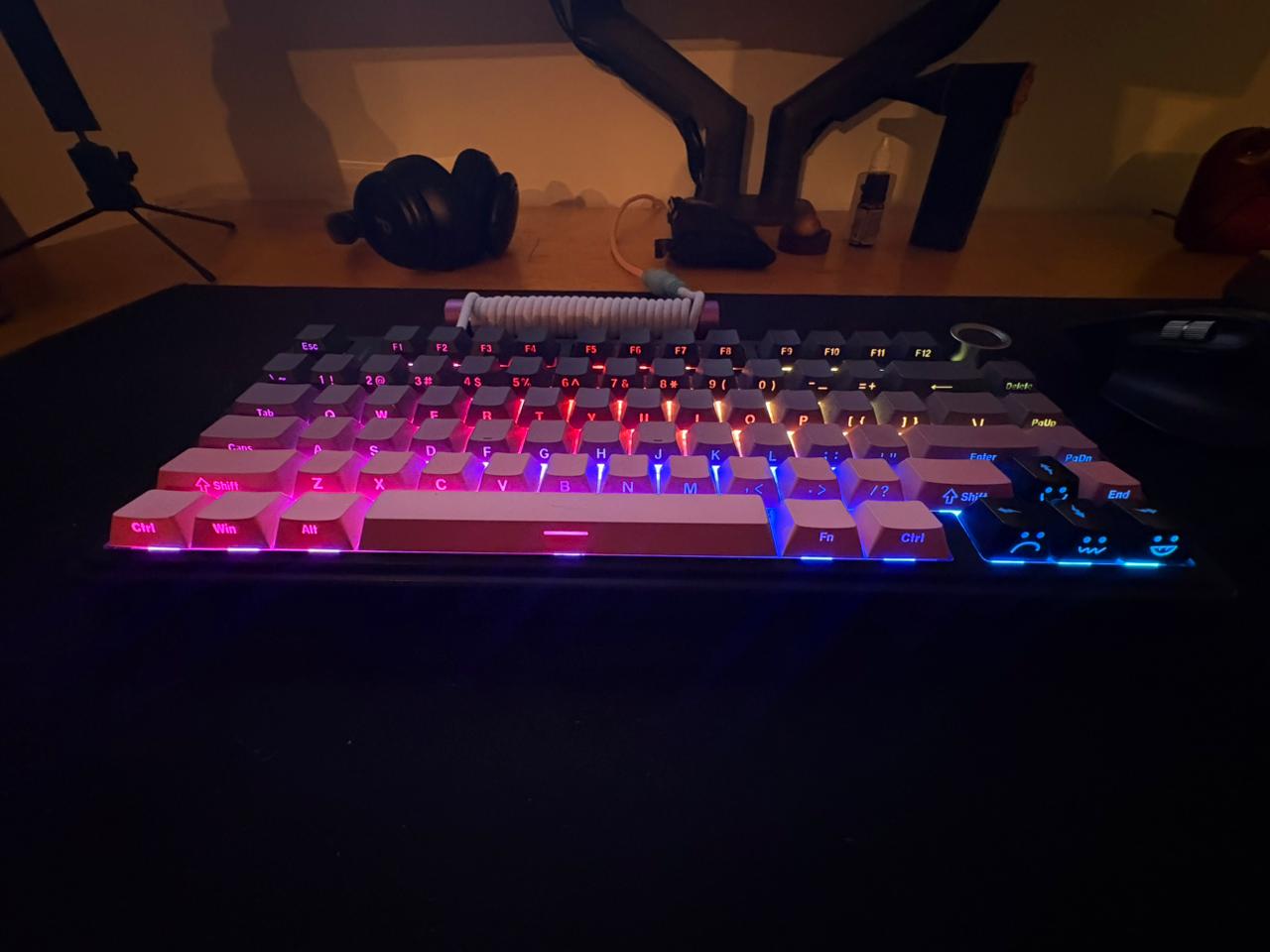 Teclado iluminado sobre deskmat preto
